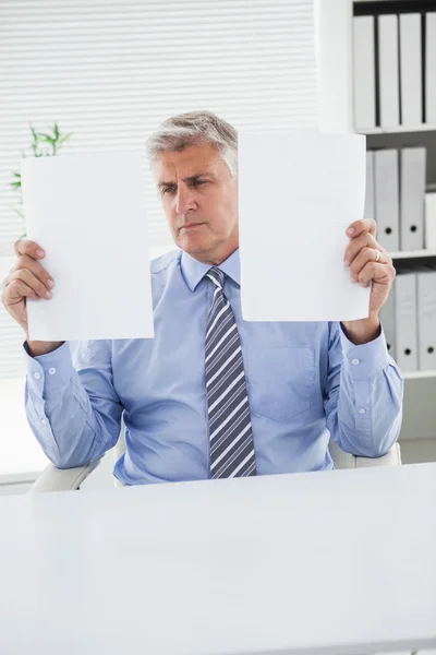 Mature businessman looking at two pages — Stock Photo, Image