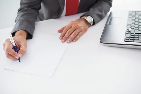 Hombre de negocios maduro escribiendo en documento —  Fotos de Stock