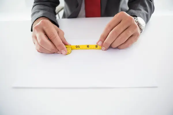 Empresário usando fita métrica na mesa — Fotografia de Stock