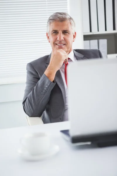 Empresário feliz em sua mesa — Fotografia de Stock