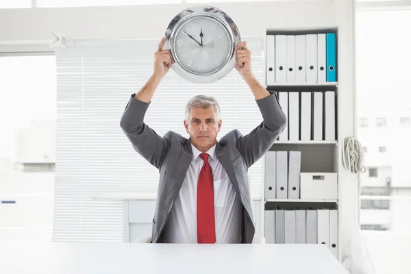 Reifer Geschäftsmann mit großer Uhr — Stockfoto