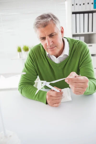 Случайный бизнесмен смотрит на модель ветряных турбин — стоковое фото