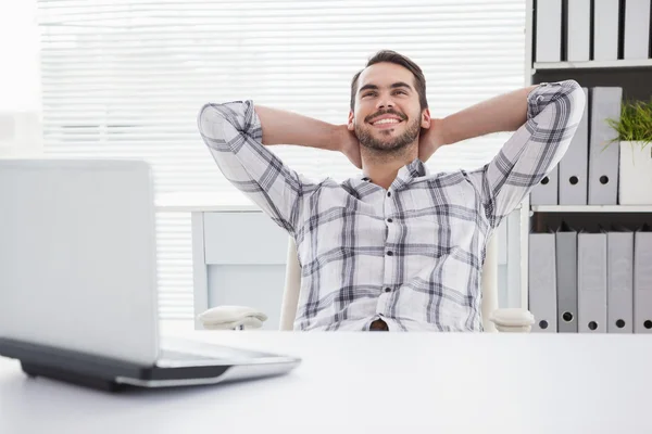 Casual affärsman avkopplande på skrivbord lutar sig tillbaka — Stockfoto