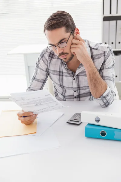 Casual affärsman readnig dokument vid sitt skrivbord — Stockfoto