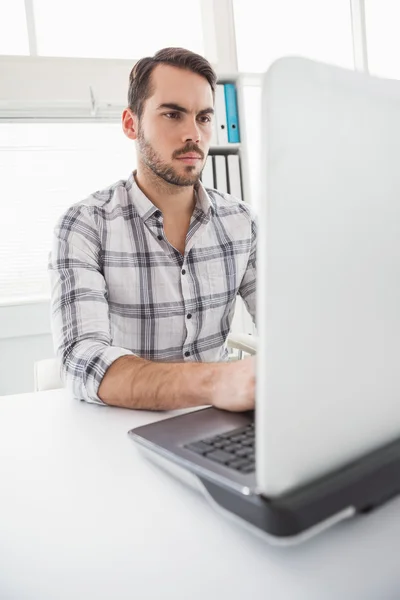 Biznesmen dorywczo za pomocą jego laptop na biurko — Zdjęcie stockowe