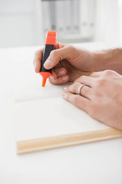 Casual zakenman markeren van een boek — Stockfoto