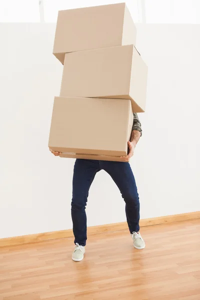 Homem equilibrando caixas de papelão pesado — Fotografia de Stock