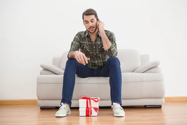 Verwirrter Mann betrachtet Geschenke auf dem Fußboden — Stockfoto