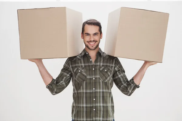 Happy man holding moving boxes — Stock Photo, Image