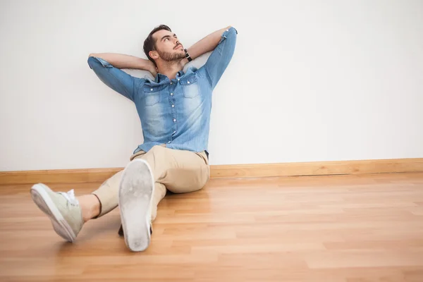 Casual man sitter på golvet tittar upp — Stockfoto