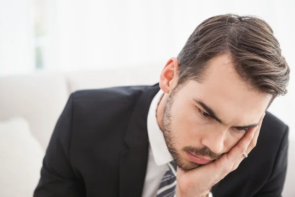 Besorgter Geschäftsmann sitzt auf seinem Sofa — Stockfoto