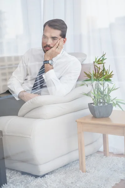 Бизнесмен, сидящий на диване, видит сквозь стекло — стоковое фото