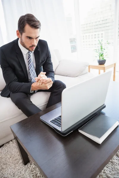Businessman using laptop on his couch — Stock Photo, Image