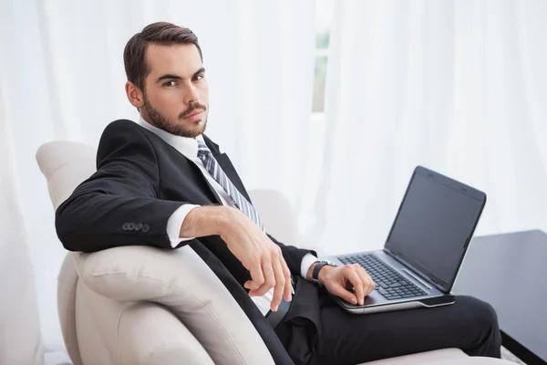 Empresário usando laptop em seu sofá — Fotografia de Stock