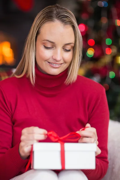 Festlig blondin öppnar julklapp — Stockfoto