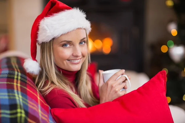 Lächelnde Blondine mit Weihnachtsmütze in der Hand — Stockfoto