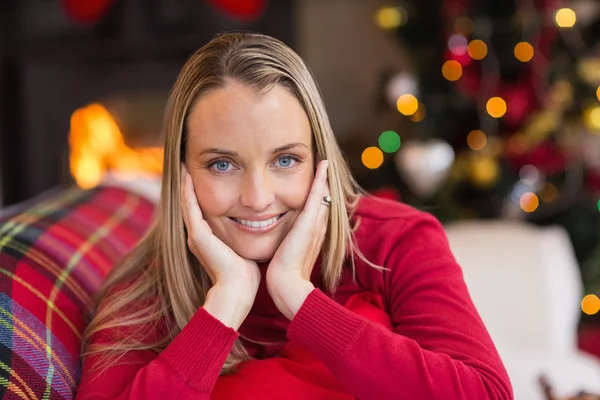 La femme qui repose sa tête sur ses mains est allongée sur le canapé — Photo