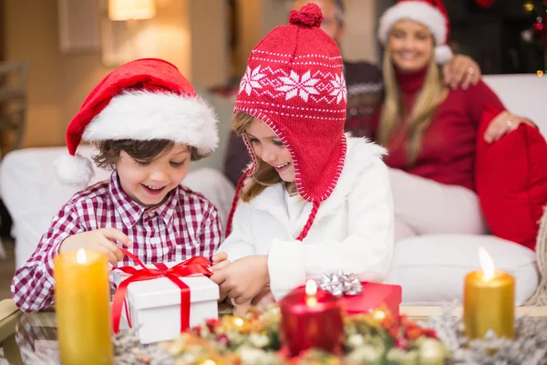 Feestelijke meisje openen een geschenk met broer — Stockfoto