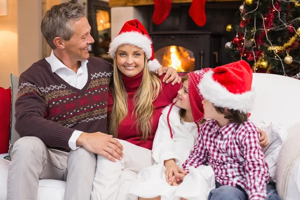 Porträtt av en leende familj sitter på soffan i juletid — Stockfoto