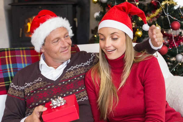 Verliefde paar in Kerstman hoed met cadeau — Stockfoto