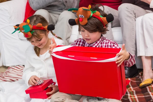 Festive sibling opening a gift — Stock Photo, Image