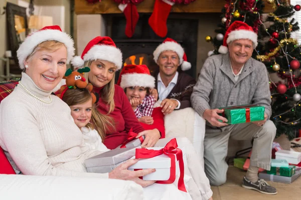 快乐的大家庭，在圣诞老人的帽子，拿着礼物的肖像 — 图库照片