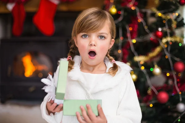 Chockad liten flicka öppnar en gåva — Stockfoto