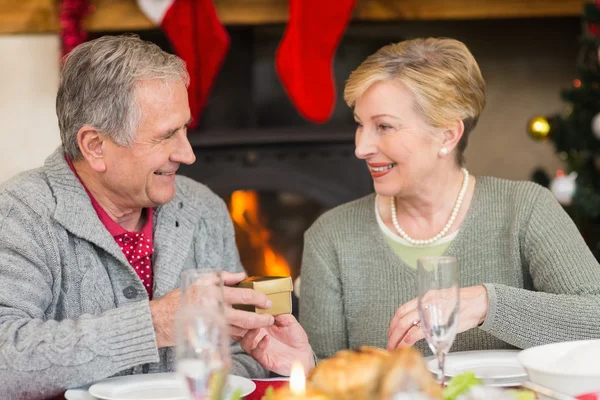 Hombre mayor dando un regalo de Navidad a su esposa — Foto de Stock