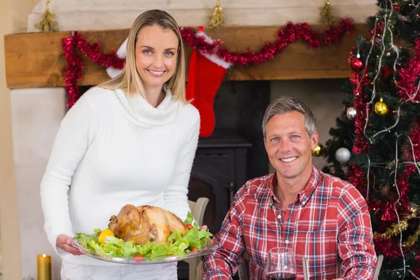 Couple smiling at camera while woman holding roast turkey — Stock Photo, Image