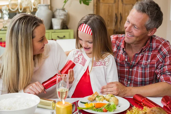 Menina puxando um biscoito de Natal com seus pais — Fotografia de Stock