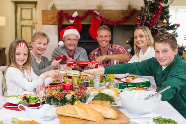 Usmívající se rodina tahání vánoční sušenky u jídelního stolu — Stock fotografie