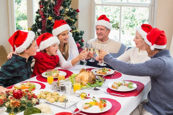 Mehrgenerationenfamilie im Weihnachtsmann prostet sich zu — Stockfoto
