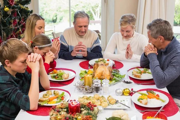 Utvidgade familjen säger grace före julbordet — Stockfoto