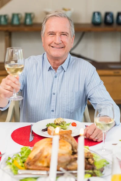 Lächelnder Mann stößt beim Weihnachtsessen an — Stockfoto