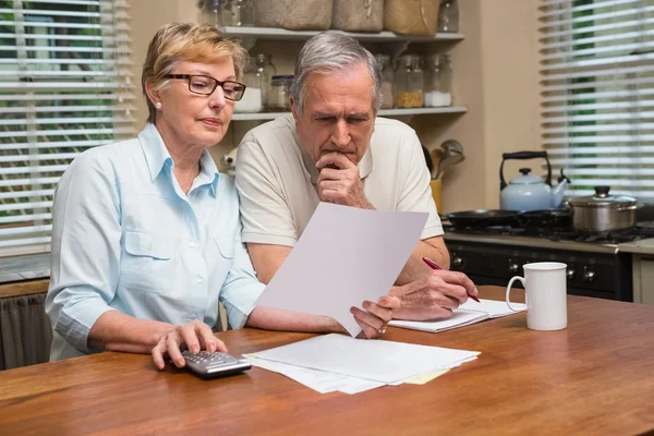 Seniorenpaar arbeitet seine Rechnungen aus — Stockfoto