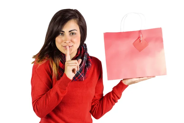 Brunette holding gift bag and keeping a secret — Stock Photo, Image