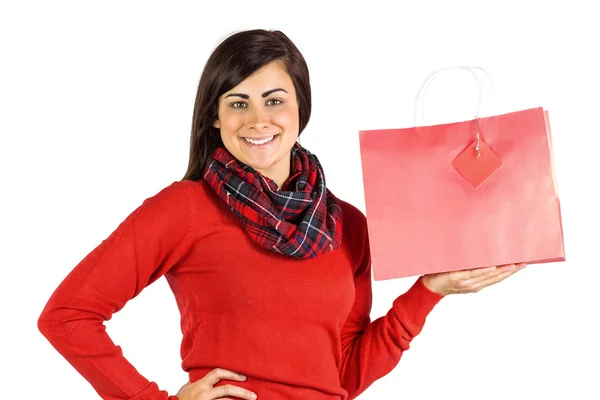 Bruna sorridente che mostra borsa regalo rossa — Foto Stock