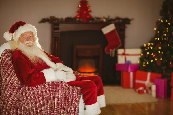 Świąteczne Mikołaj siedząc na kanapie na Boże Narodzenie — Zdjęcie stockowe