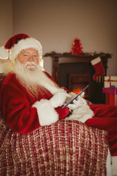 Santa tableta alegre tocando en el sofá — Foto de Stock