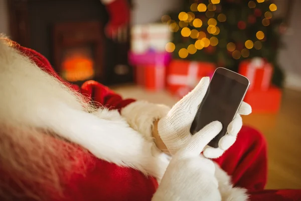 Santa claus dotýká smartphone na Vánoce — Stock fotografie