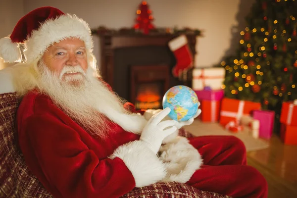 Noel Baba bir küre tutan gülümseyerek — Stok fotoğraf