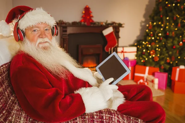 Weihnachtsmann hört Musik und nutzt Tablet — Stockfoto