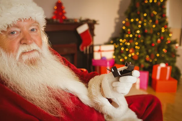 Father christmas holding engagement ring with his box — Stock Photo, Image