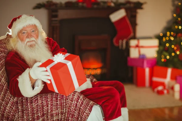 Fröhliche Weihnachtsmänner, die ein Geschenk machen — Stockfoto