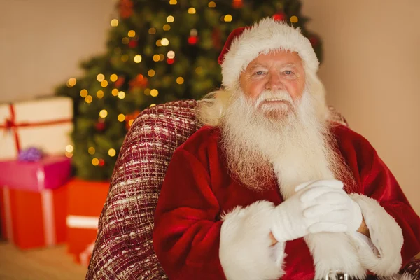 Lächelnder Weihnachtsmann entspannt sich auf dem Sessel — Stockfoto