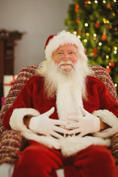 Portrét happy santa drží jeho břicho — Stock fotografie