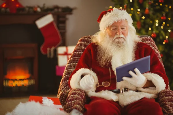 Santa, drží si brýle a použití tabletu — Stock fotografie