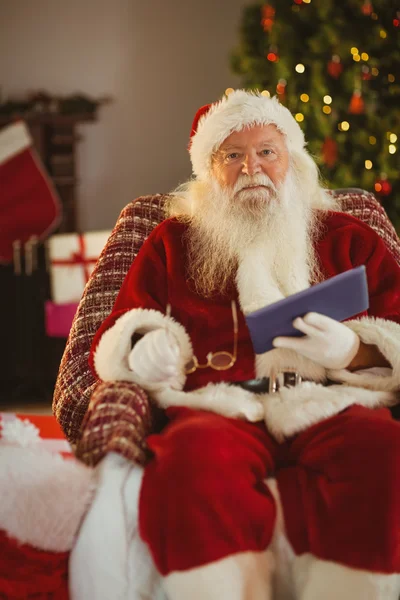 Happy santa držení sklenice a tablet — Stock fotografie