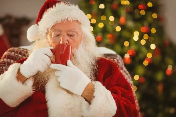 Santa claus drinking a hot beverage — Stock Photo, Image