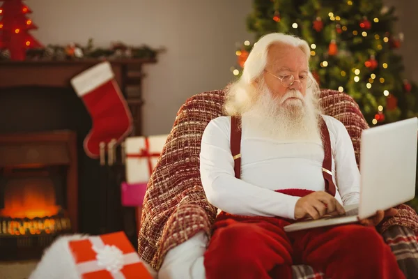 Santa claus typing on laptop — Stock Photo, Image